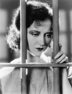 Lamenting: Young woman in a jail, looking sad