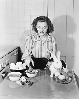 Coloring: Young woman in her kitchen coloring Easter eggs