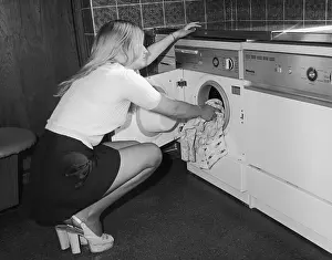 Slingbacks: Young woman loading a washing machine