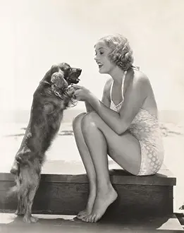 Cocker: Young woman playing with Cocker Spaniel at beach