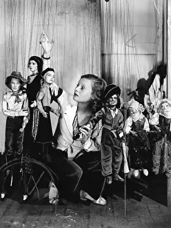 Organize: Young woman playing with puppets on the string