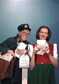 Mailman: Young woman posed with mailman at mailbox getting mail