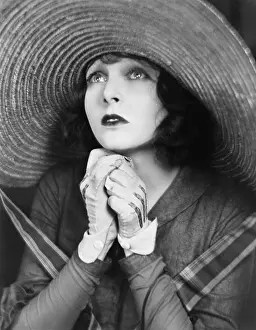 Lamenting: Young woman praying in a big hat