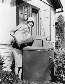 Abode: Young woman putting garbage into a garbage can