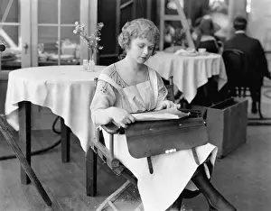 Ponder: Young woman sitting on a chair and reading documents