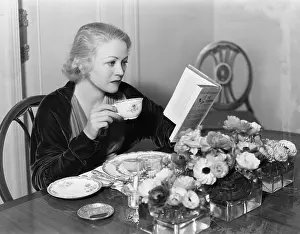 Ashtray: Young woman sitting at the dining table holding
