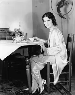 Breakfasts: Young woman sitting at a table having breakfast tea