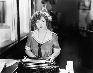 Employ: Young woman sitting in front of a typewriter