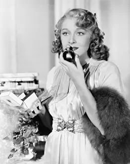 Smells: Young woman smelling perfume
