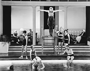 Tossing: Young woman standing on a diving board surrounded