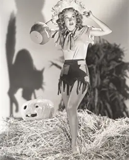 Fringes: Young woman standing on haystack in front of shadow