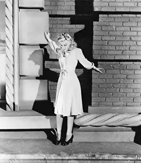 Petrifying: Young woman standing on the ledge of a building