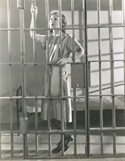Penitentiary: Young woman standing in prison cell