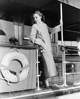 Dressed Up: Young woman standing at the railing of a boat