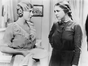 Displeasure: Two young woman talking with each other while doing