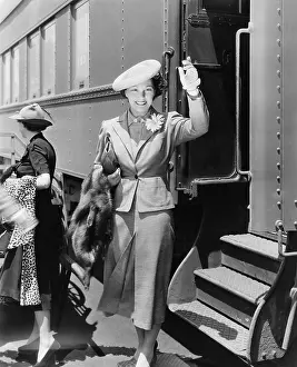 Getaway: Young woman next to train waving