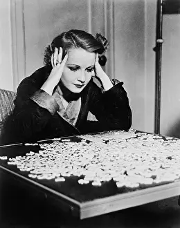 Solutions: Young woman trying to solve a puzzle