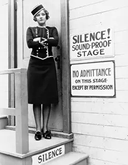 Committing: Young woman in a uniform standing with her arms