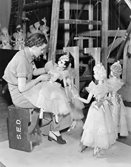 Organize: Young woman working with puppets on a string