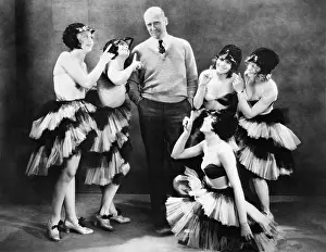 Cooperate: Five young women dancing around a man