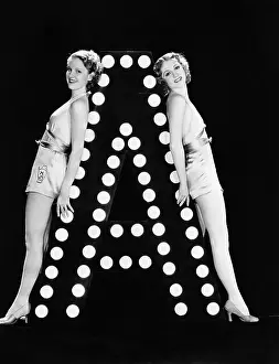Imagining: Two young women posing with the letter A