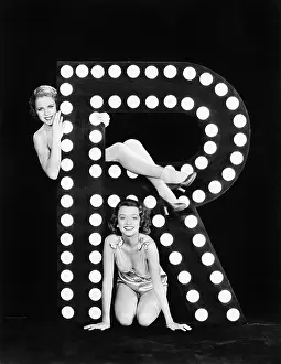 Imagining: Two young women posing with the letter R