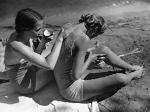 Sunscreen: Two young women putting sunscreen on
