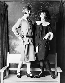 Appealing: Two young women standing on a bench smiling and