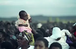 Mugabe: Zimbabwe, 2000: A child is lifted above the crowd at